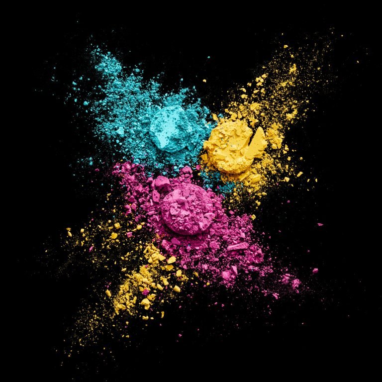 Creative photo of smashed makeup. There are three colors- yellow, blue and pink