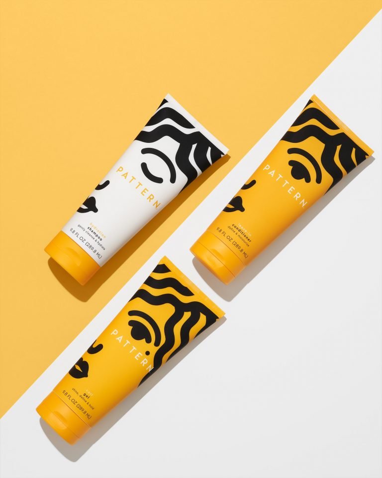 Creative flat lay cosmetics photography of the conditioner, gel and shampoo. Background consists of two colors yellow and white.